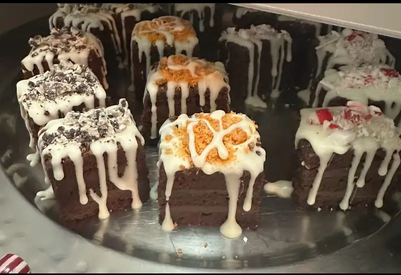 Plate of brownies with white frosting and different toppings