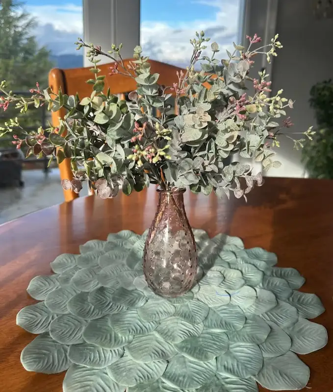Plant arrangement in a vase on a wooden table