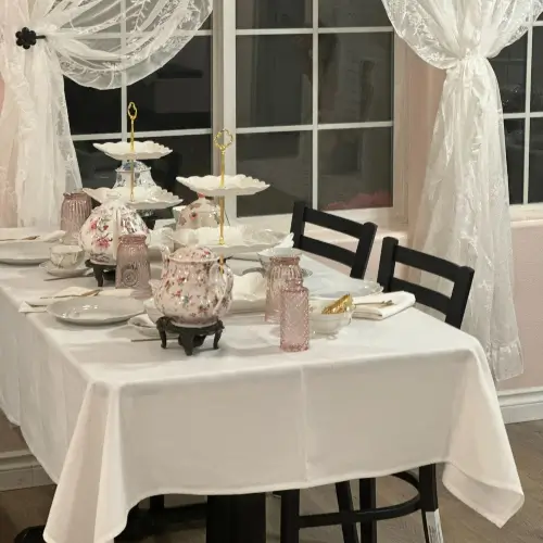 Elegant tea table set up with tea pots, cups and dessert trays | Honey Bunny’s Tea House